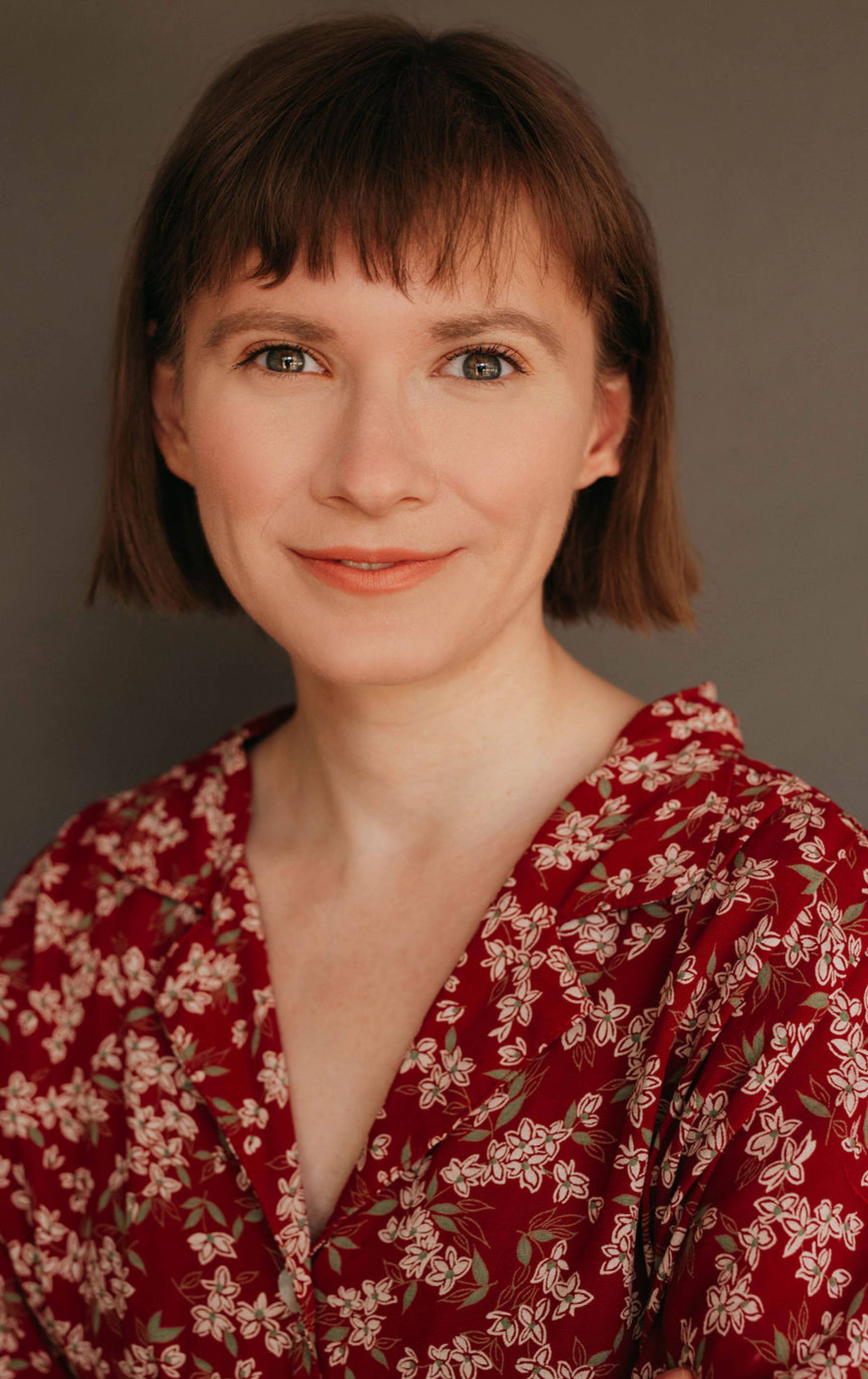 A photograph of social media manager Sarah Kaufmann wearing a red floral dress.